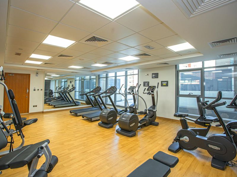 Bright gym interior with modern equipment and plants.