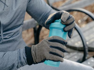 Sporty water bottle standing on a dark bench.